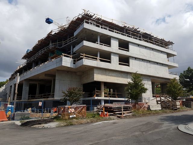 McKinnon — two and a half floors of underground parking, three levels of apartment units above grade, and one level of retail and amenity space.